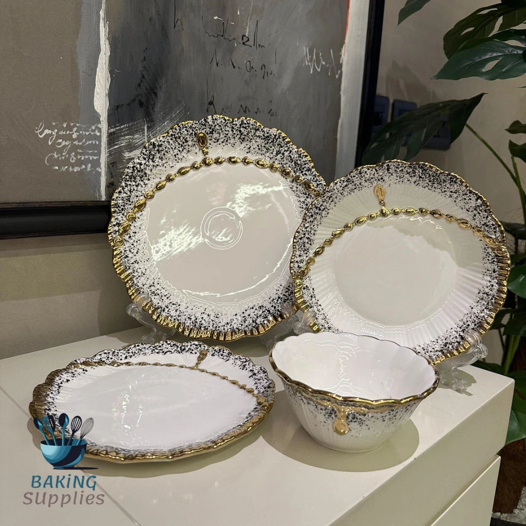 Set of ceramic dishes with gold and black patterns.