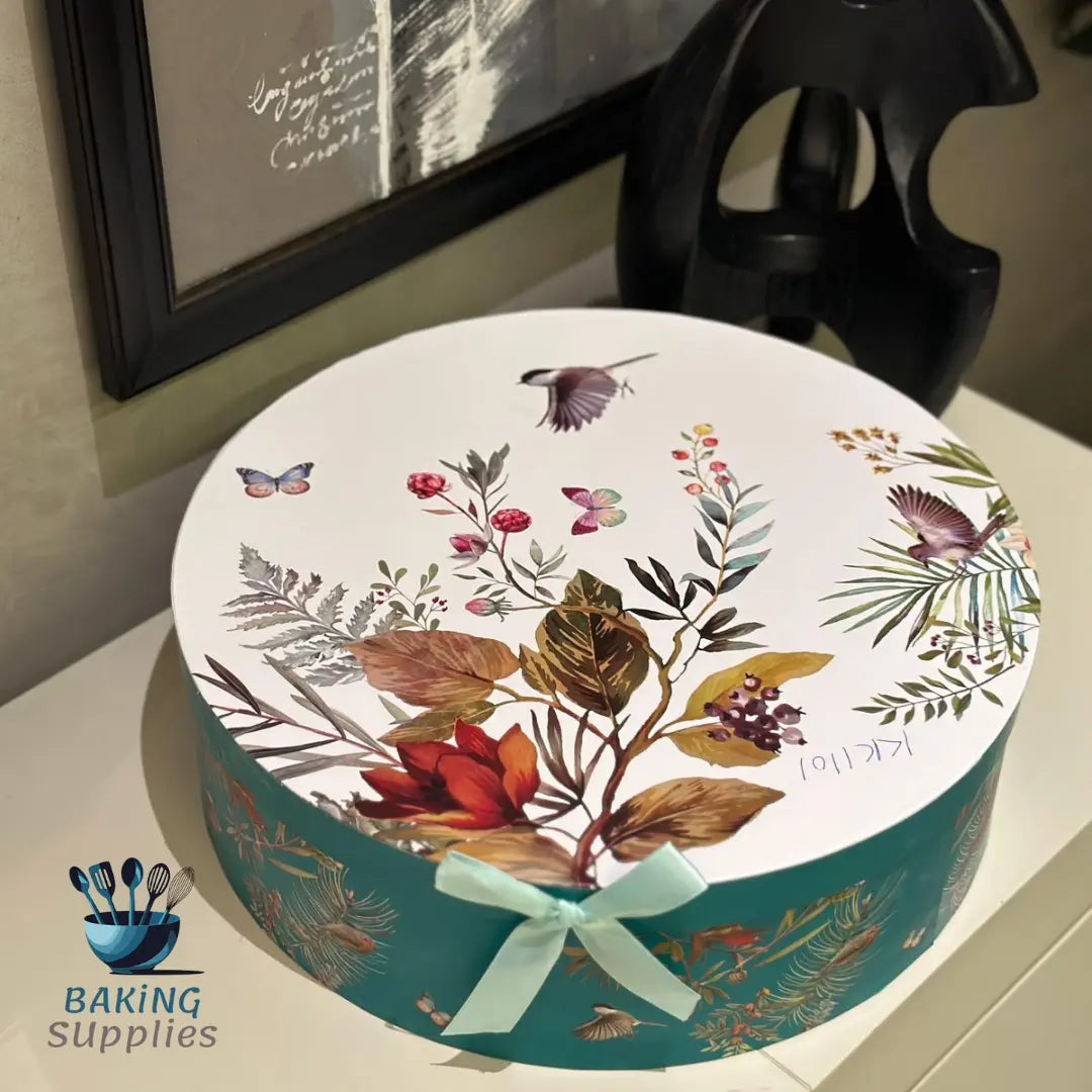 Decorative round gift box with floral design and ribbon on a surface
