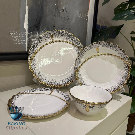 Set of ceramic dishes with gold and black patterns.