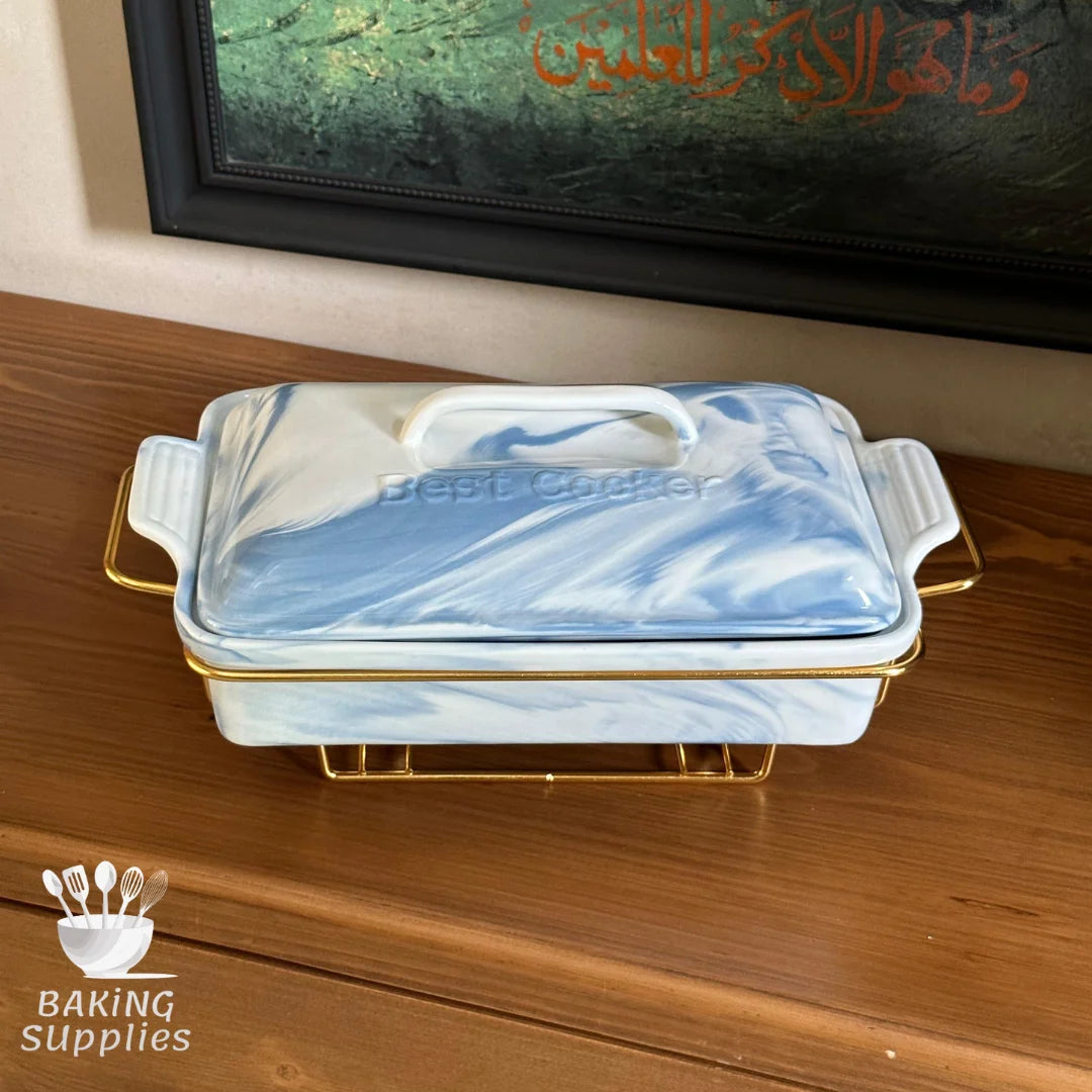 Marble-patterned baking dish with gold accents on a wooden surface, with 'Baking Supplies' logo.